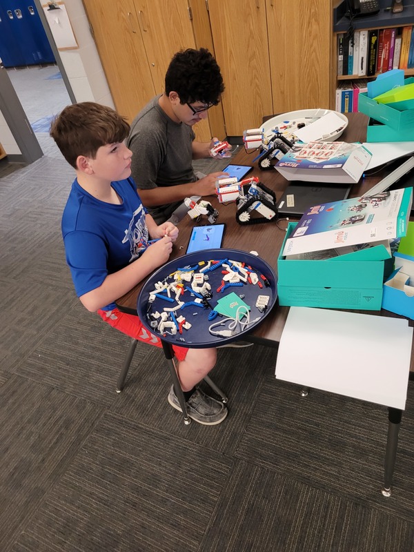 Two students building their robots in the teacher's classroom